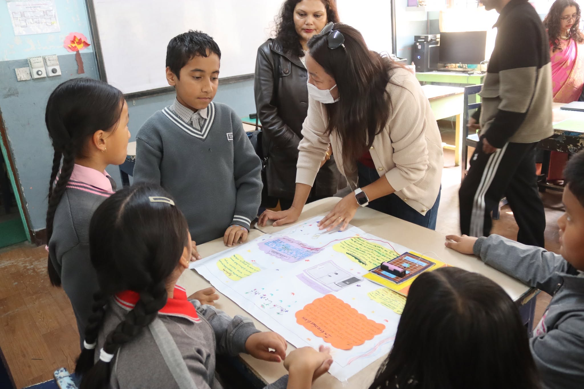 Junior students presenting an innovation project with teacher guidance